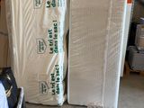 many mattresses stacked up in a warehouse with pallets