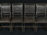 six chaises anciennes sont alignées devant un fond noir