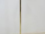 a gold floor lamp with a white shade on top of it