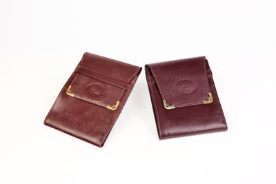 deux portefeuilles en cuir marron posés sur une surface blanche