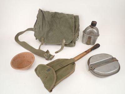 a bag, a spoon, a bottle, and a brush on a white surface