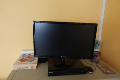 a flat screen tv sitting on a desk next to a dvd player