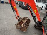 a red excavator that is parked in a parking lot