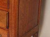 a small wooden chest of drawers on a white background