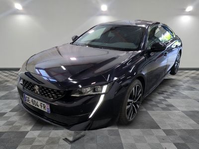 la photo d'une voiture noire garée sur un sol en damier