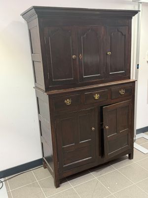 une armoire en bois à deux portes, surmontée d'un tiroir