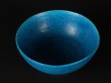 blue bowl on a black surface with a black background