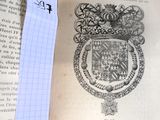 un livre sur lequel figure le dessin d'un blason