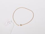 a gold chain bracelet with a small gold ball on it
