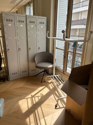 a room with a bed, a chair, and lockers in it
