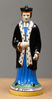 a figurine of a man wearing a robe and a hat