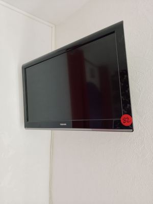 a flat screen tv mounted on the wall above a bed