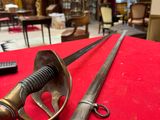 two swords on a red table in a room