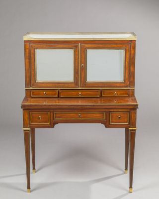 an antique writing desk with two drawers and a marble top