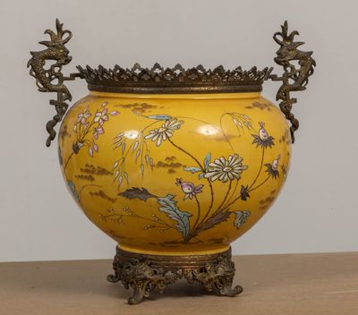 un vase jaune orné de fleurs, posé sur une table