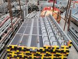 un gros tas de barres d'acier empilées les unes sur les autres dans un entrepôt