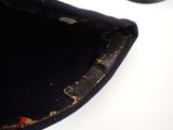 a close up of a hat on a table with a cell phone