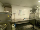 une cuisine avec de nombreux plans de travail en inox