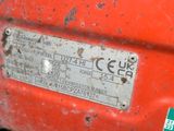 a close up of a metal plate on a red vehicle
