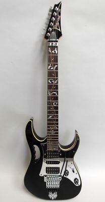 an electric guitar sitting on top of a white surface