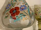 a glass vase and a glass goblet sitting on a shelf