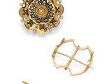 a close up of a brooch and a pin on a white surface