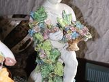a figurine of a woman holding a basket of flowers