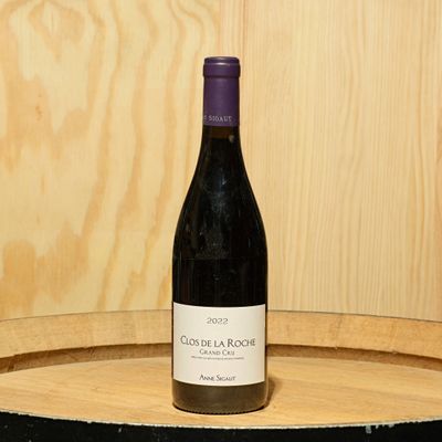 a bottle of wine sitting on top of a barrel