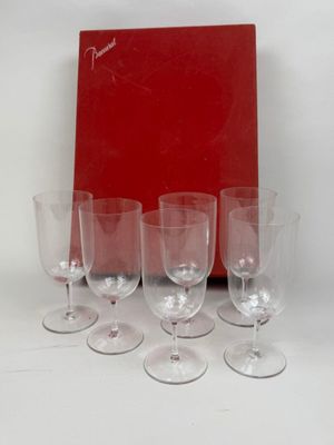quatre verres à vin vides posés devant une boîte rouge