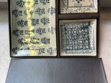three square plates in a black box with blue and white designs
