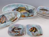 de nombreuses assiettes ornées de poissons, posées sur une table