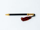 un stylo orné d'un pompon, posé sur une table