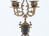 a gold and black candelab with three candles on it