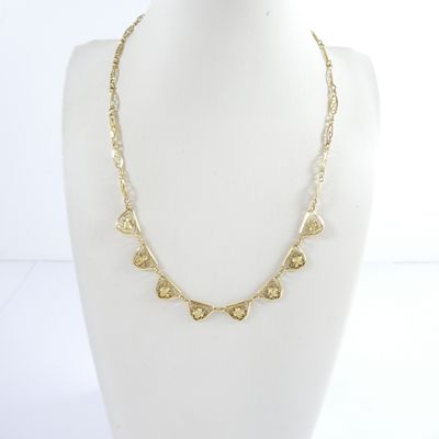 the necklace is made of gold metal and has a heart shaped design