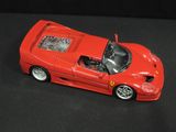 a red toy car that is sitting on a black surface