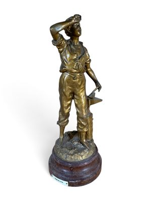 statue of a man with a hat on his head holding a hammer