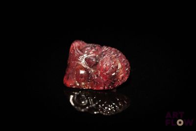 a close up of a red diamond on a black surface