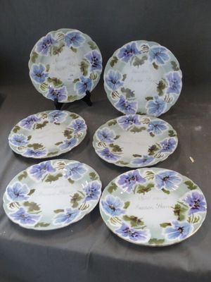 six assiettes bleues et blanches ornées de fleurs violettes, posées sur une table