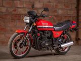 a red and black motorcycle parked in front of a brick wall