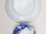 a blue and white bowl and a white plate on a table