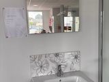 une salle de bains équipée d'un lavabo, d'un miroir et d'une douche