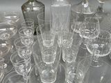 many glasses and a decanter sitting on a table