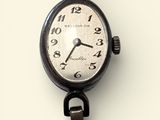 a black and white photo of a wrist watch on a white surface