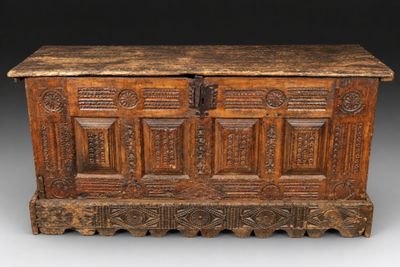 un vieux coffre en bois avec des gravures et des sculptures sur les côtés