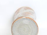 a close up of a vase on a white surface