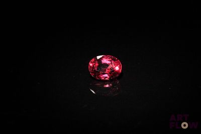 a close up of a pink diamond on a black surface