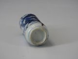 a small blue and white vase on a white surface