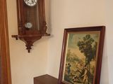 a picture of a clock on the wall next to a painting
