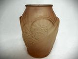 a brown vase that is sitting on a white surface