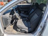 the interior of a silver car with black seats and a steering wheel